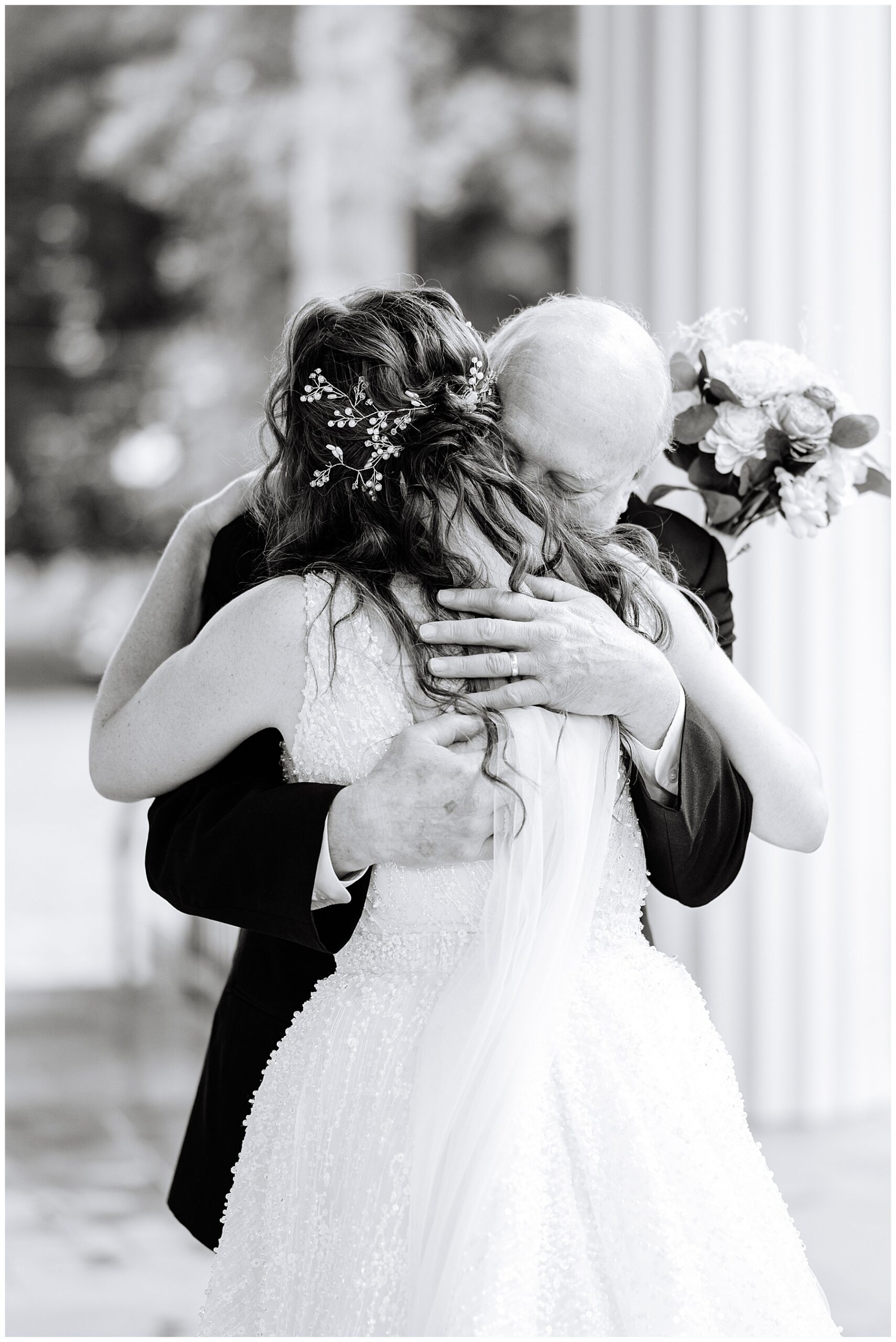 Charlotte wedding photographer captures bride hugging family member during emotional first look.